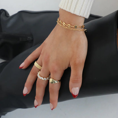 a woman's hand with a gold chain bracelet